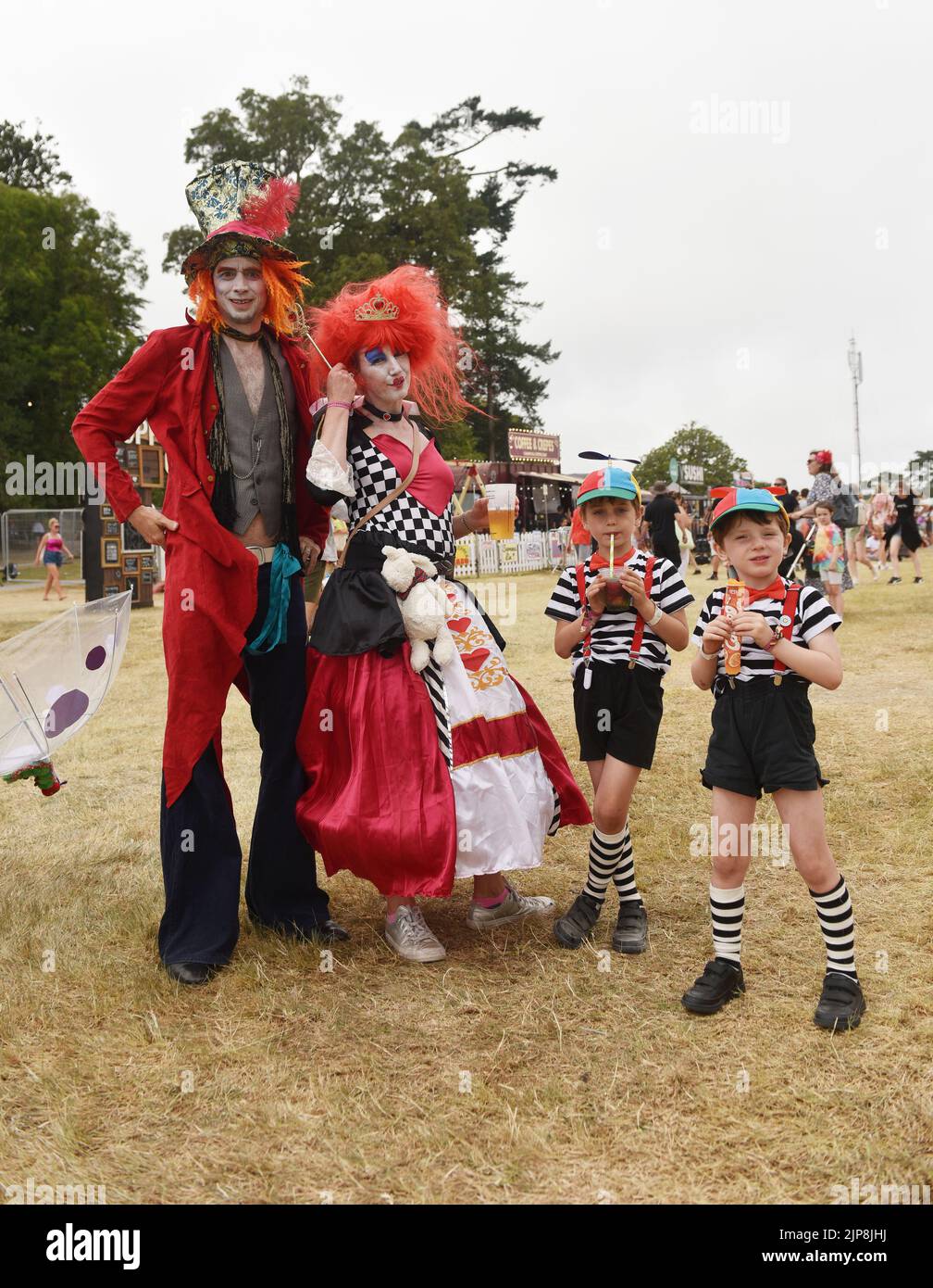 A family kitted out in Alice in Wonderland inspired outfits.  Scenes at the family friendly festival Camp Bestival, Lulworth Castle and Estate, Dorset UK July 28 - 31 2022 Stock Photo