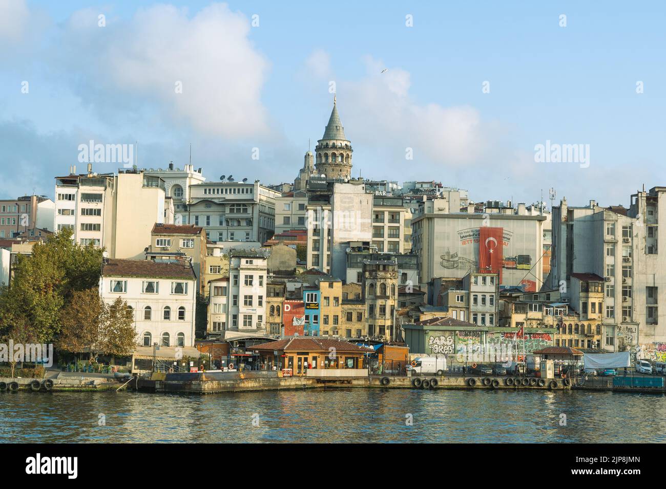 Galata Tower with old houses, Karaköy pier and sea view. Cloudy sky ...