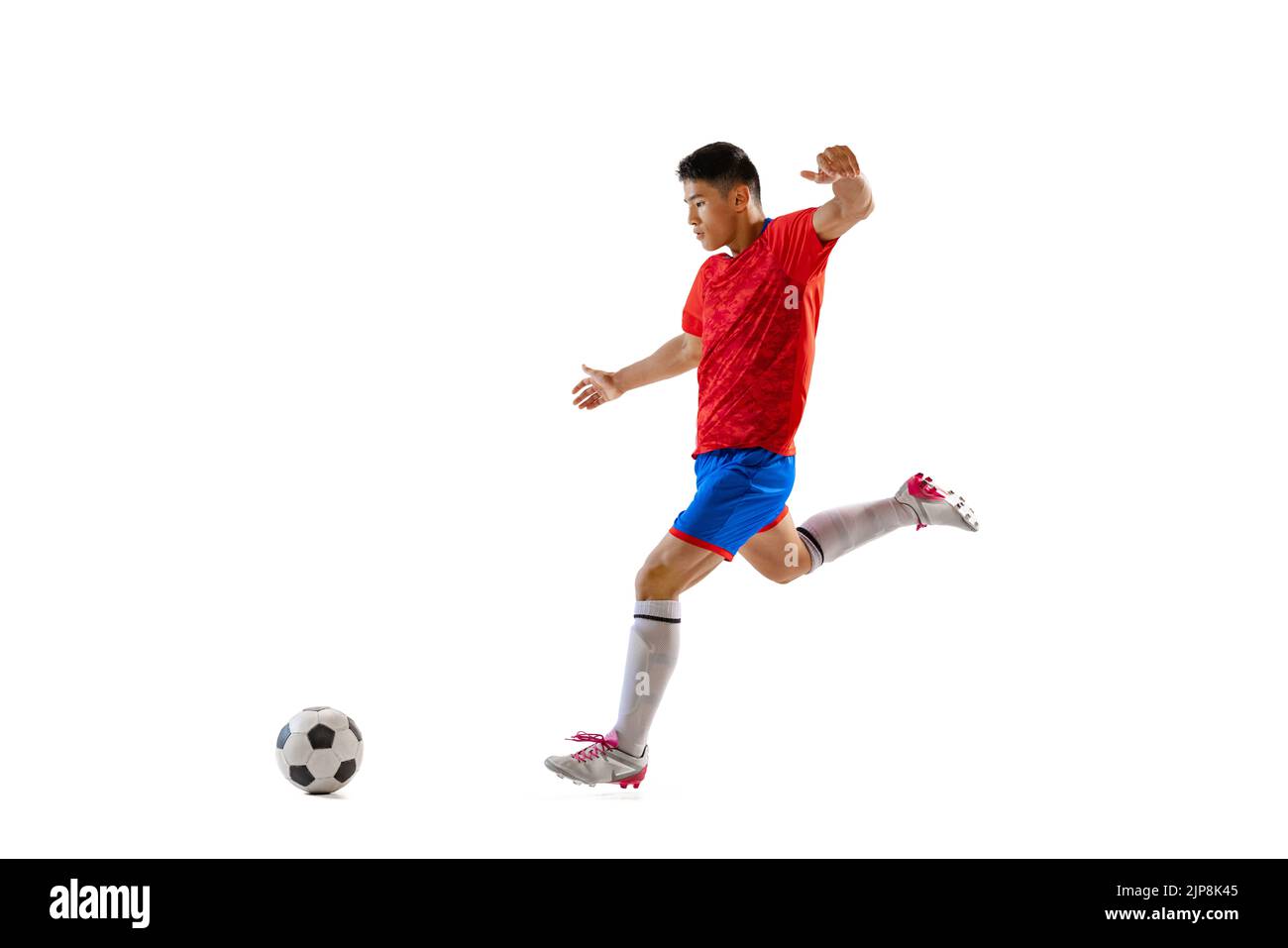 Dynamic portrait of young man, professional football player in motion, training, dribbling ball