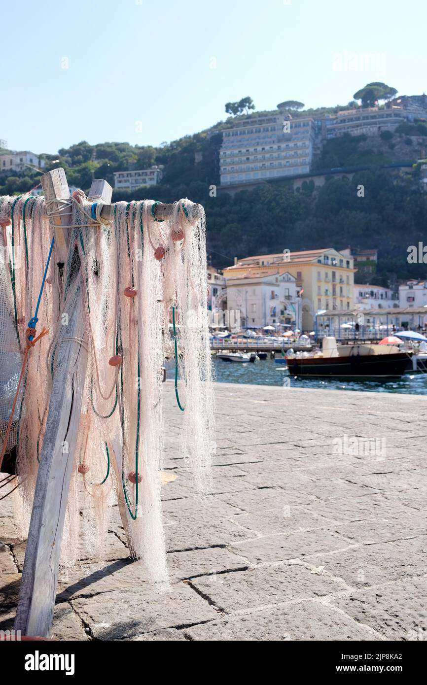 Fishing nets of traditional fisherman hang out to dry in the village port of Marina Grande in Sorrento Italy. A popular area for sea fish restaurants. Stock Photo