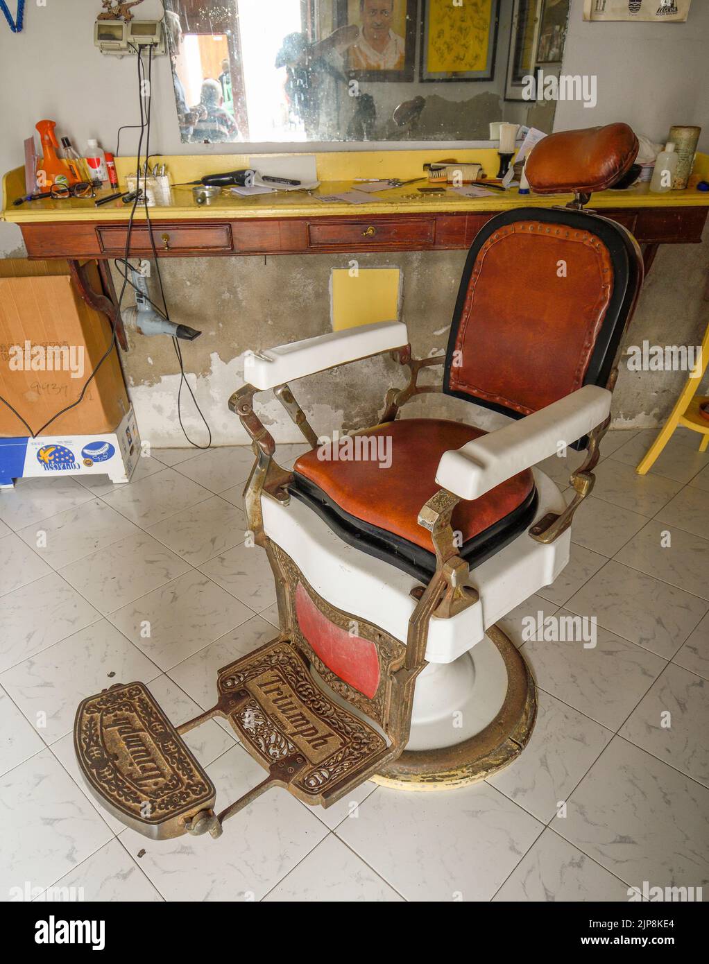 Old barbershop with the chair for haircuts in the center of the image Stock Photo