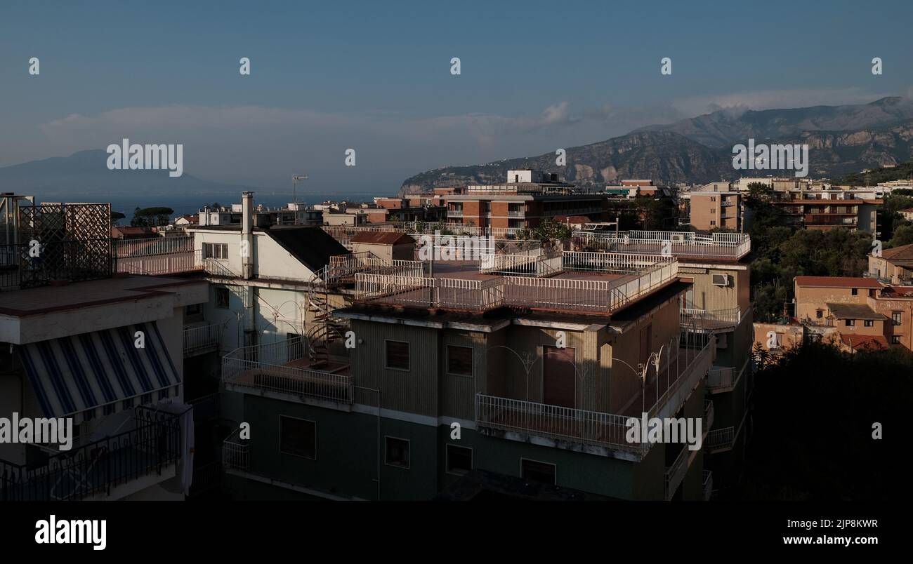 An image taken high above the rooftops of Sorrento Italy showing sun terraces and Mount Vesuvius and lattari mountains. Stock Photo