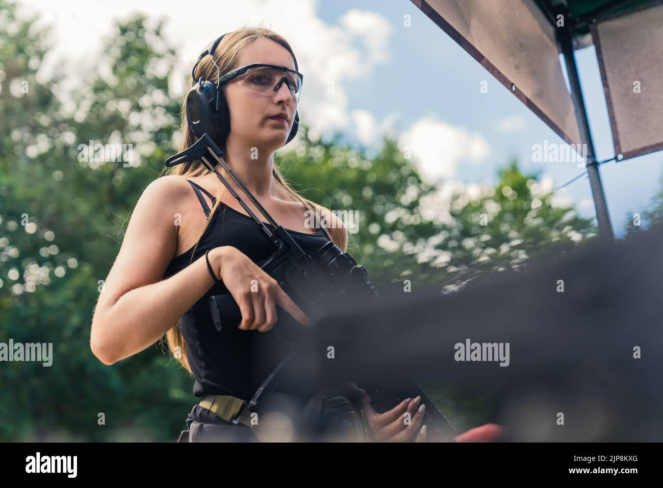 Caucasian woman wearing safety headphones and goggles looking at camera