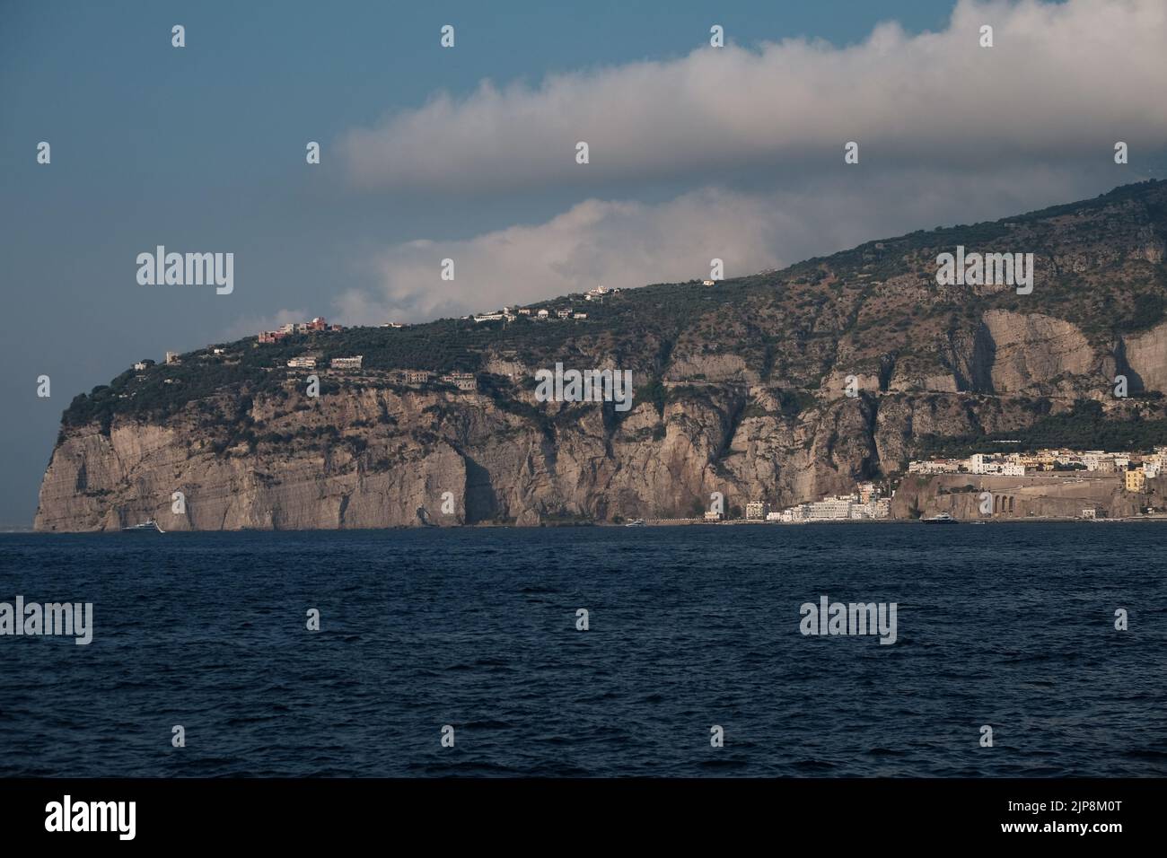 View of part of the Sorrento peninsula with building perched on top looking out into the Bay of Naples. Stock Photo