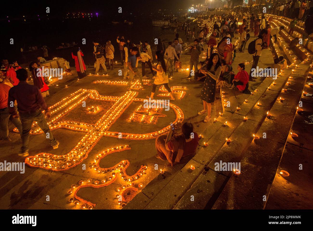 Women lighting oil lamps on Dev Deepavali, Varanasi, Banaras, Benaras, Kashi, Uttar Pradesh, India Stock Photo