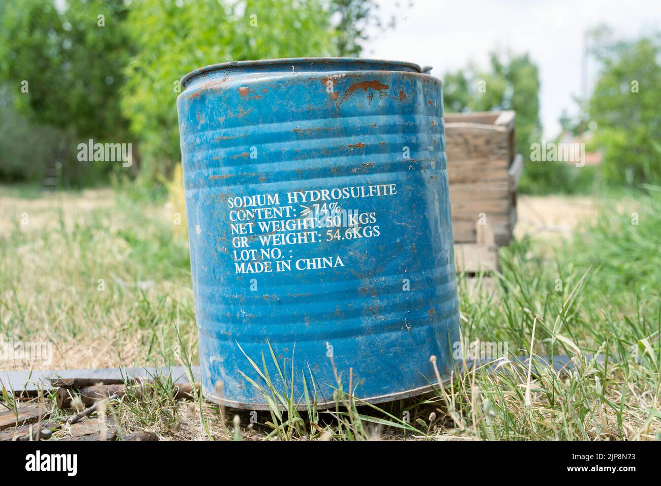 Sodium hydrosulfide, chemical solution barrel, garden view at the background. Stock Photo