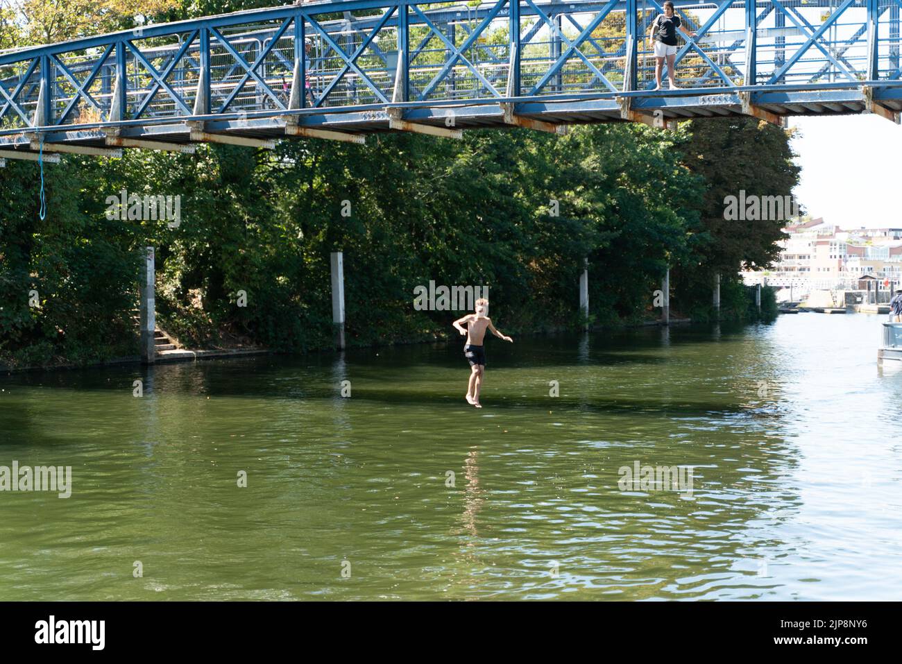 Boy Jumping From Bridge Stock Photo