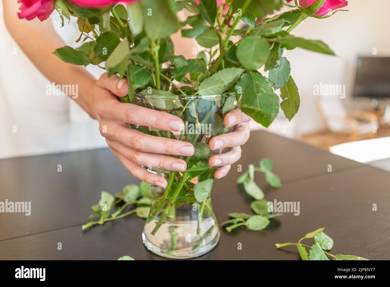 Woman hands holding a vase with roses. Stock Photo