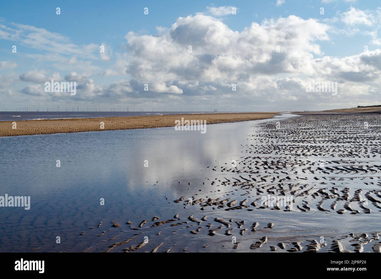 clouds reflected in water on low tide beach Stock Photo