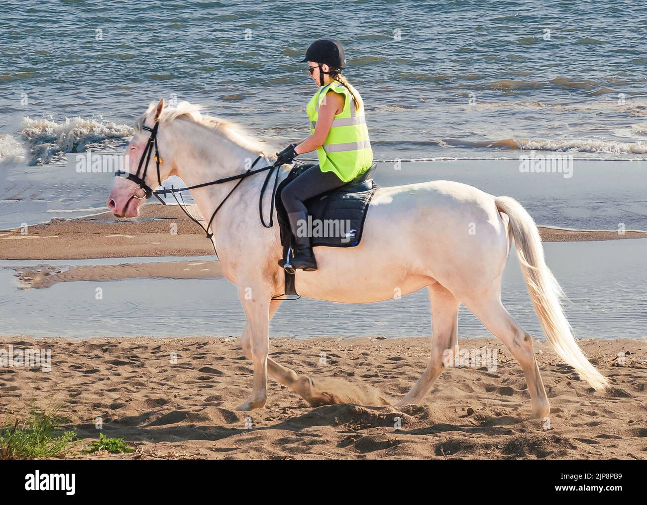 Girl horse riding on beach Stock Photo