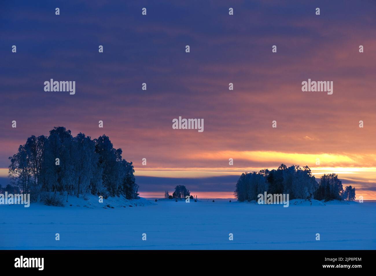 Frozen lake and islands, winter landscape. Sunset sky. Stock Photo