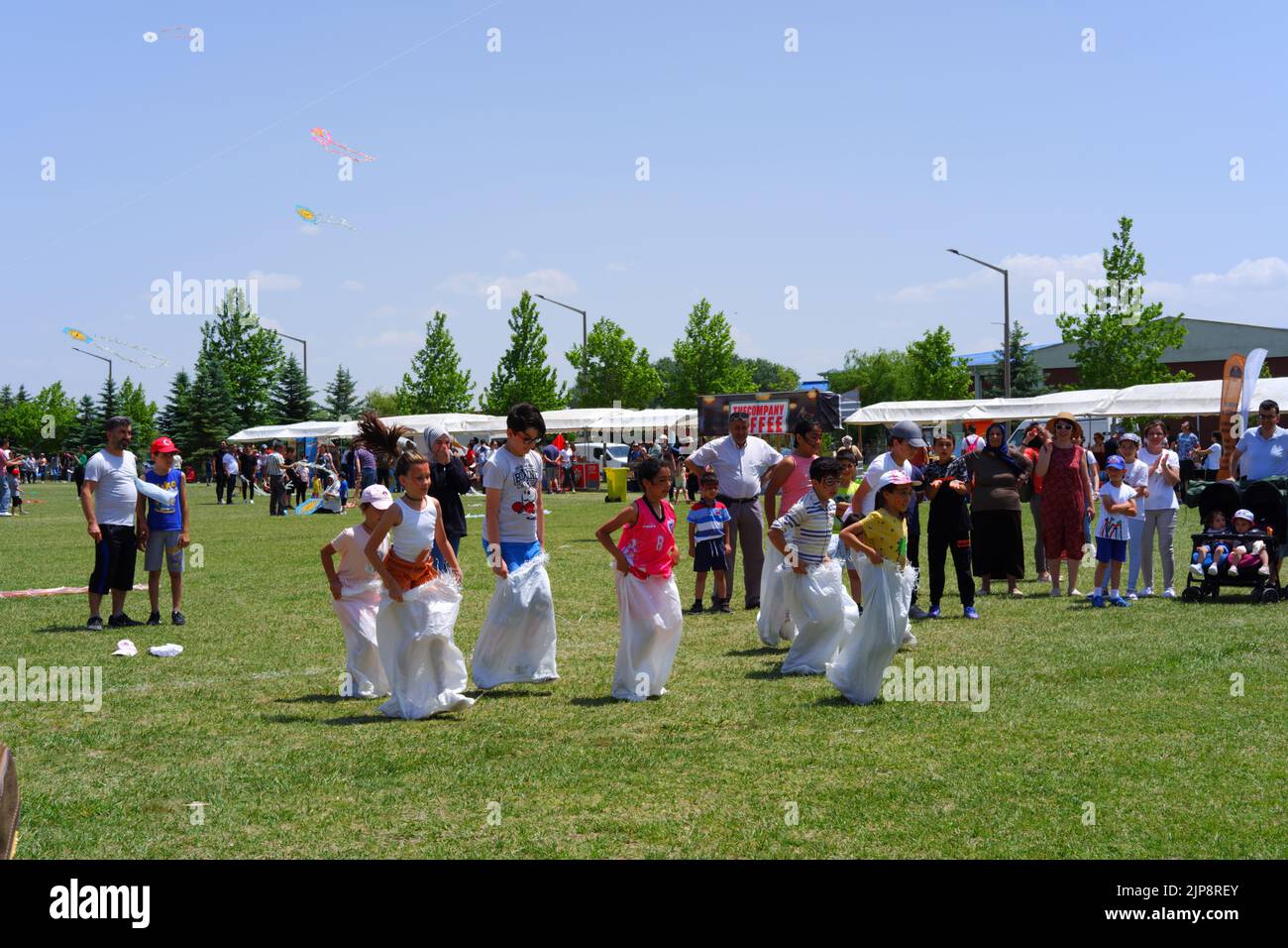 People and kids having fun at gunnysack race in summer outdoor Stock Photo