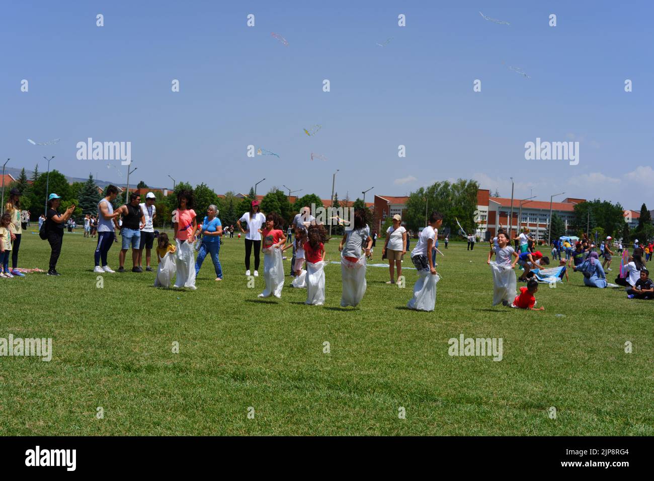 People and kids having fun at gunnysack race in summer outdoor Stock Photo