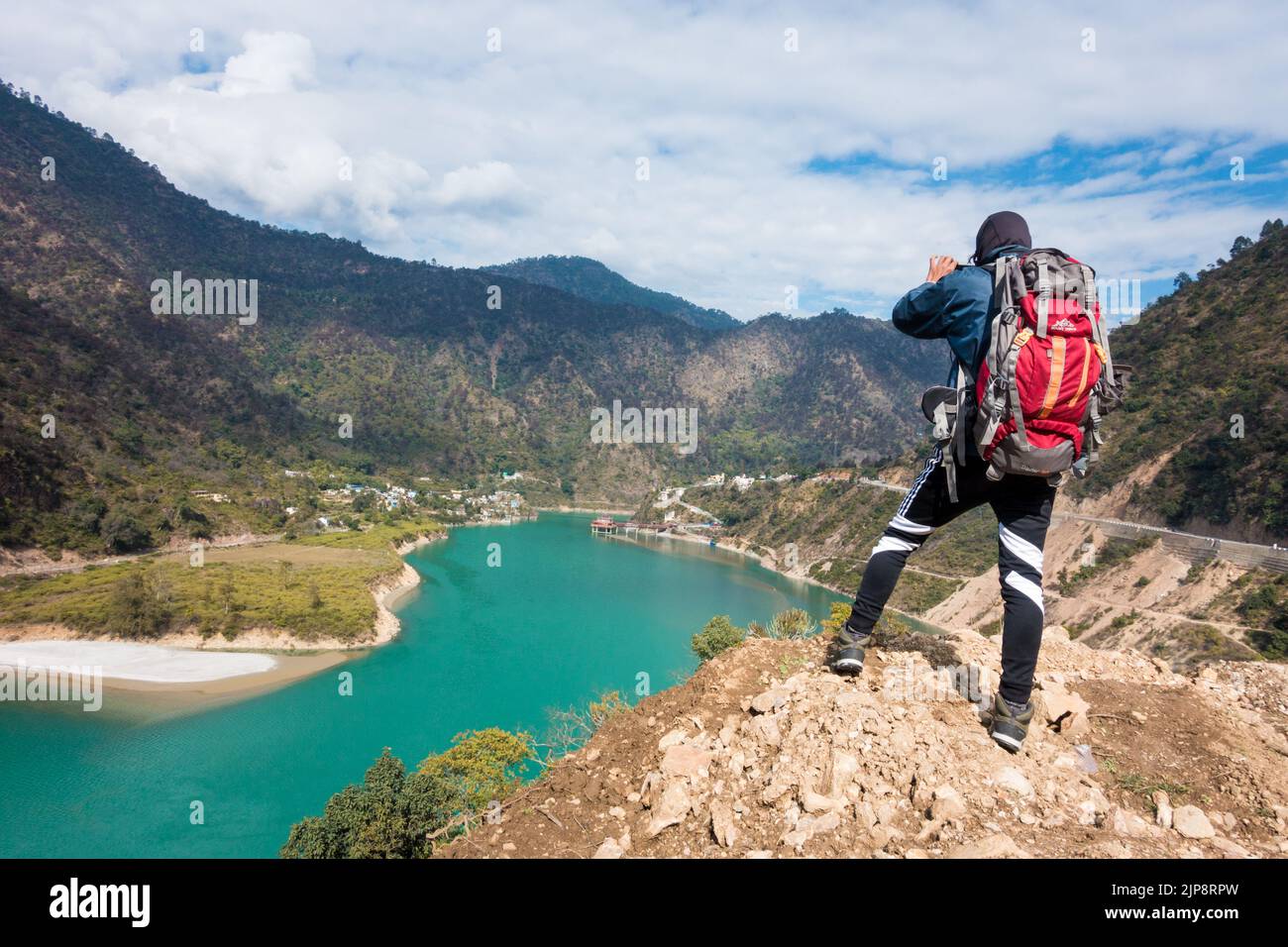 January 21st, 2022, Srinagar Uttarakhand India. A male tourist with a backpack taking a photograph of Dhari Devi hinduTemple located on the banks of Al Stock Photo