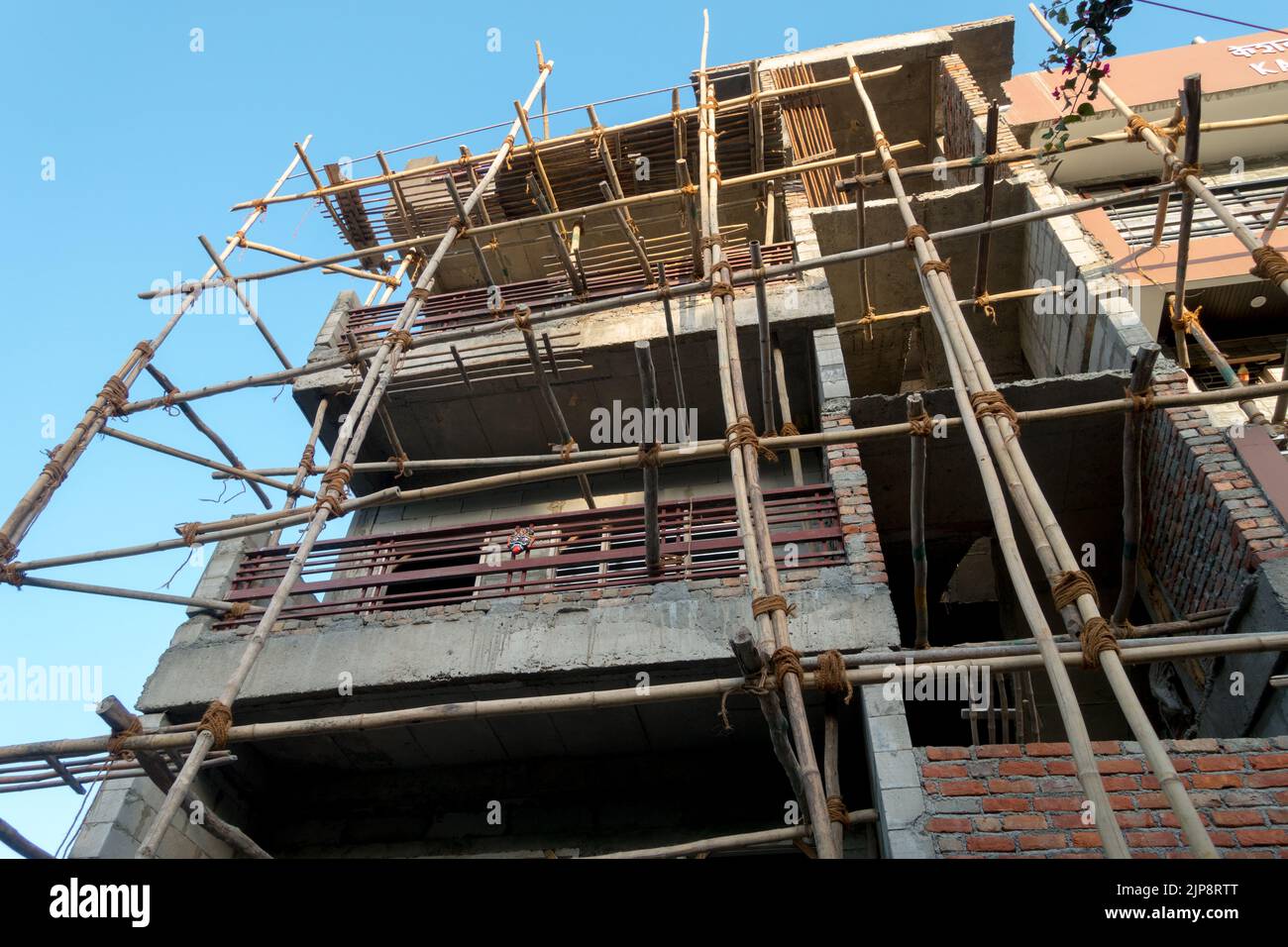 March 25th 2022. dehradun INDIA. An under construction multiple story building with support logs and climbing ropes. Stock Photo