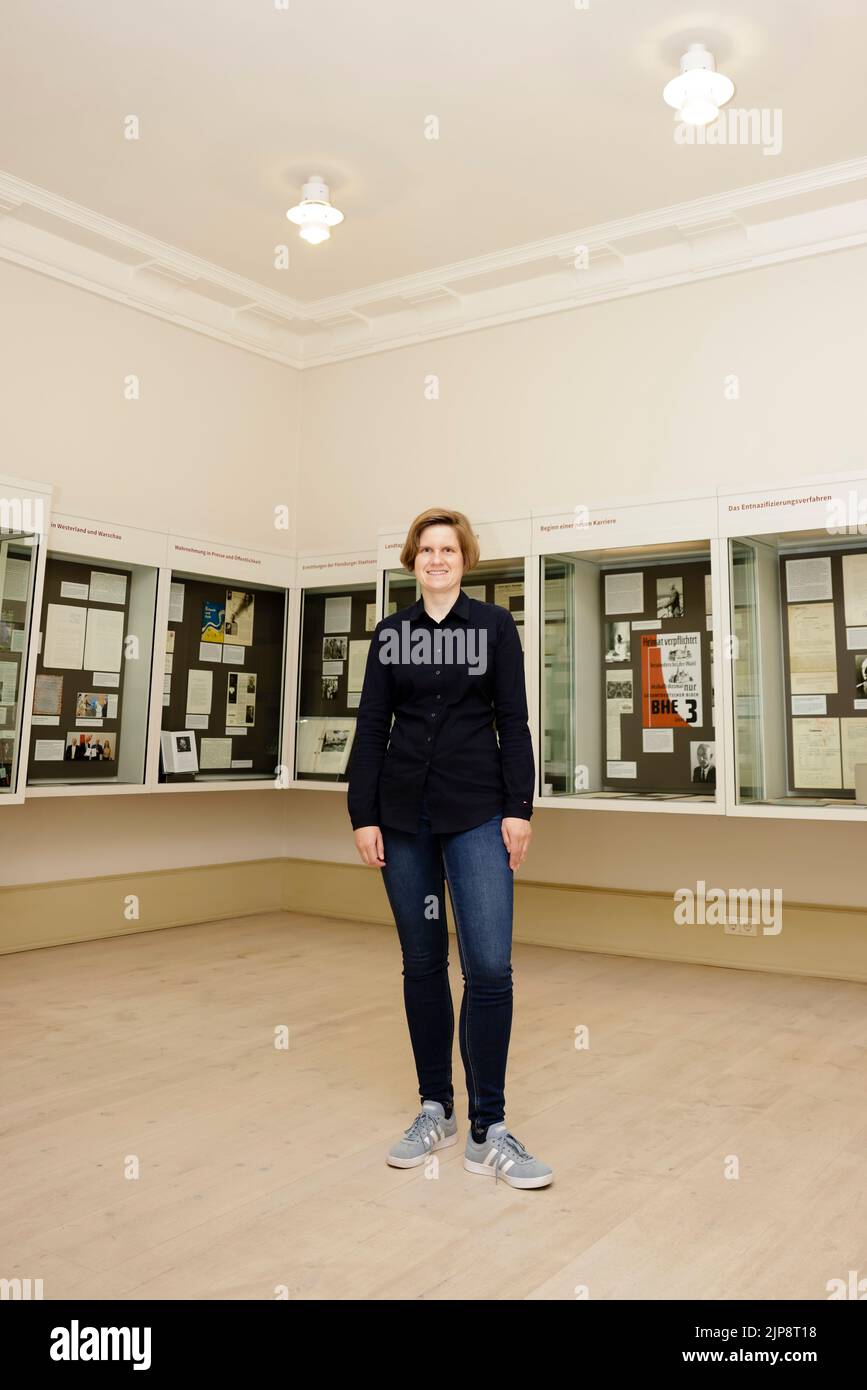 16 August 2022, Schleswig-Holstein, Schleswig: Julia Liedtke, curator at the Schleswig-Holstein State Archives, stands in front of display cases. On August 17, 2022, the exhibition "Heinz Reinefarth. From Nazi War Criminal to Member of the State Parliament" will open. Reinefarth was a German lieutenant general in the Waffen SS and was responsible for, among other things, the suppression of the Warsaw Uprising, in which tens of thousands of civilians were shot under his command. Reinefarth was never prosecuted for his actions. He managed to embark on a political career, becoming a member of the Stock Photo