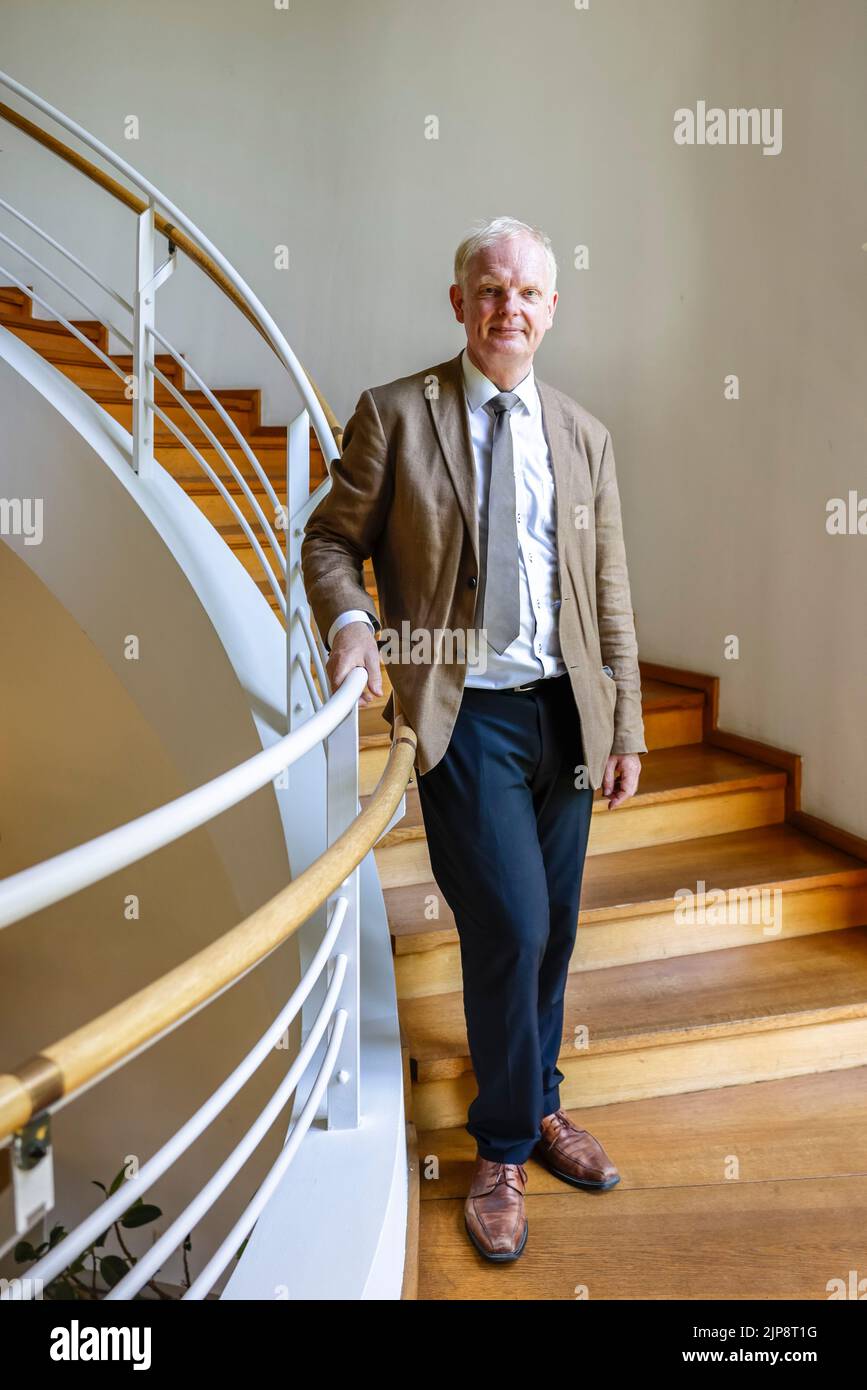 16 August 2022, Schleswig-Holstein, Schleswig: Rainer Hering, Senior Director of Archives at the Schleswig-Holstein State Archives, stands for a portrait photo on a staircase railing. On August 17, 2022, the exhibition 'Heinz Reinefarth. From Nazi War Criminal to Member of the State Parliament' will open. Reinefarth was a German lieutenant general in the Waffen SS and was responsible for, among other things, the suppression of the Warsaw Uprising, in which tens of thousands of civilians were shot under his command. Reinefarth was never prosecuted for his actions. He managed to embark on a poli Stock Photo