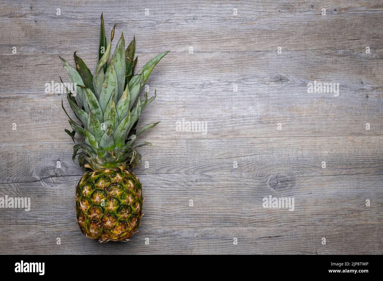 Whole pineapple on a wooden table Stock Photo