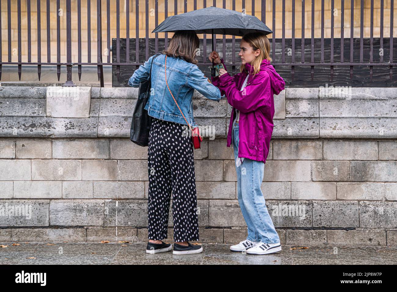 Westminster London, UK. 16 August 2022 . Pedestrians shelter with an umbrella outside parliament  during rain showers as the drought ends  after the prolonged dry spell and the driest summer in 46 years as the met office issues a yellow warning for thunderstorms and flash floods . Credit. amer ghazzal/Alamy Live News Stock Photo
