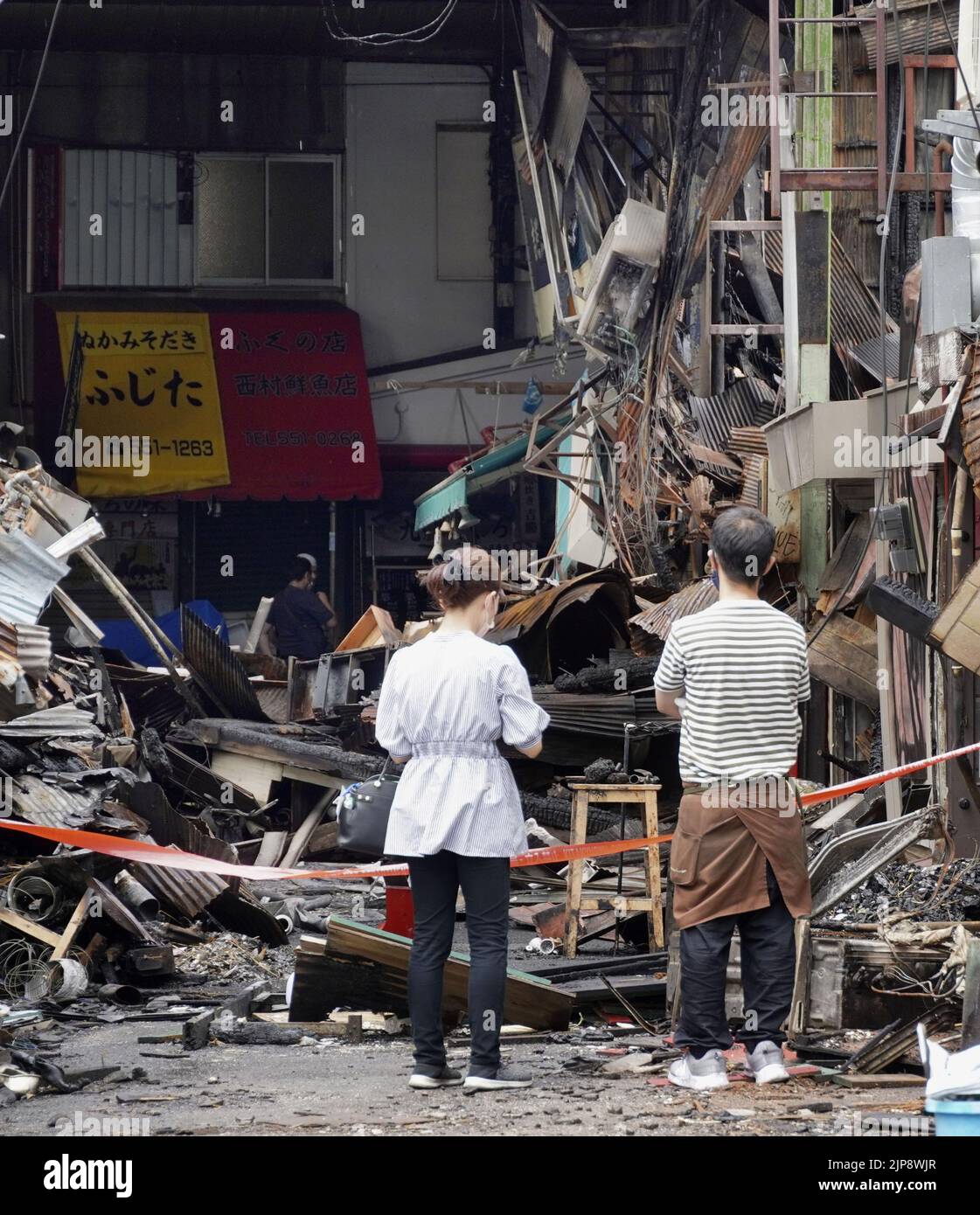 People look at the ruins of the fire-hit Tanga market in Kitakyushu, southwestern Japan, on Aug. 16, 2022. A fire broke out on the night of Aug. 10. (Kyodo)==Kyodo  Photo via Newscom Stock Photo