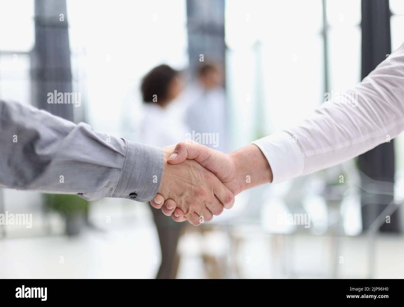Close up people shaking hands on blurred background Stock Photo