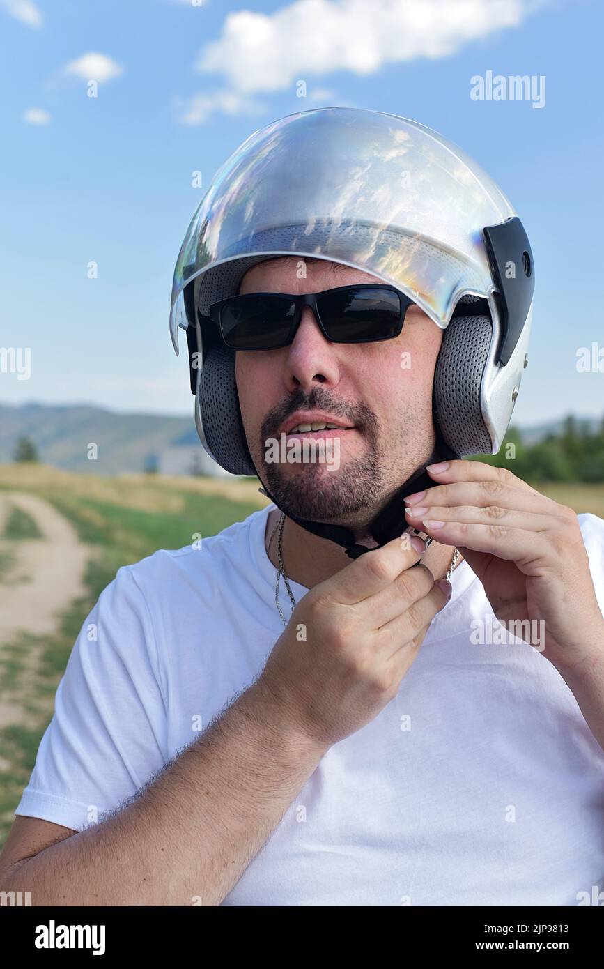 a man fastens his motorcycle helmet Stock Photo