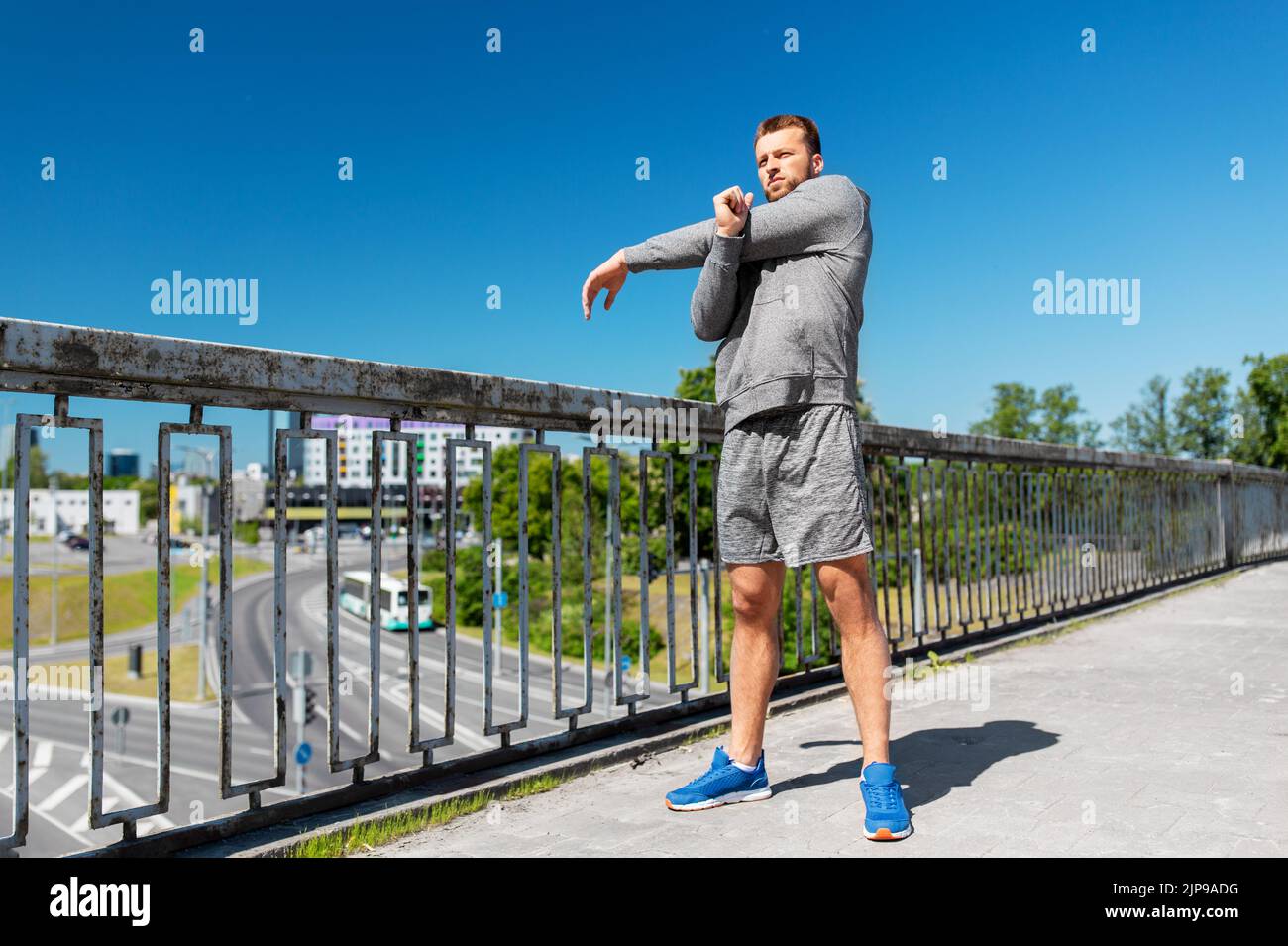 man stretching hand and shoulder on bridge Stock Photo - Alamy