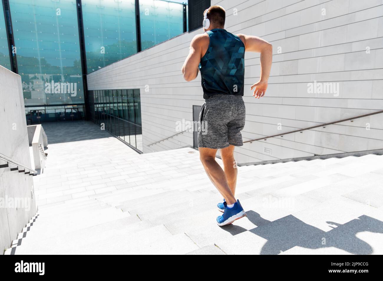 young man in headphones running downstairs Stock Photo