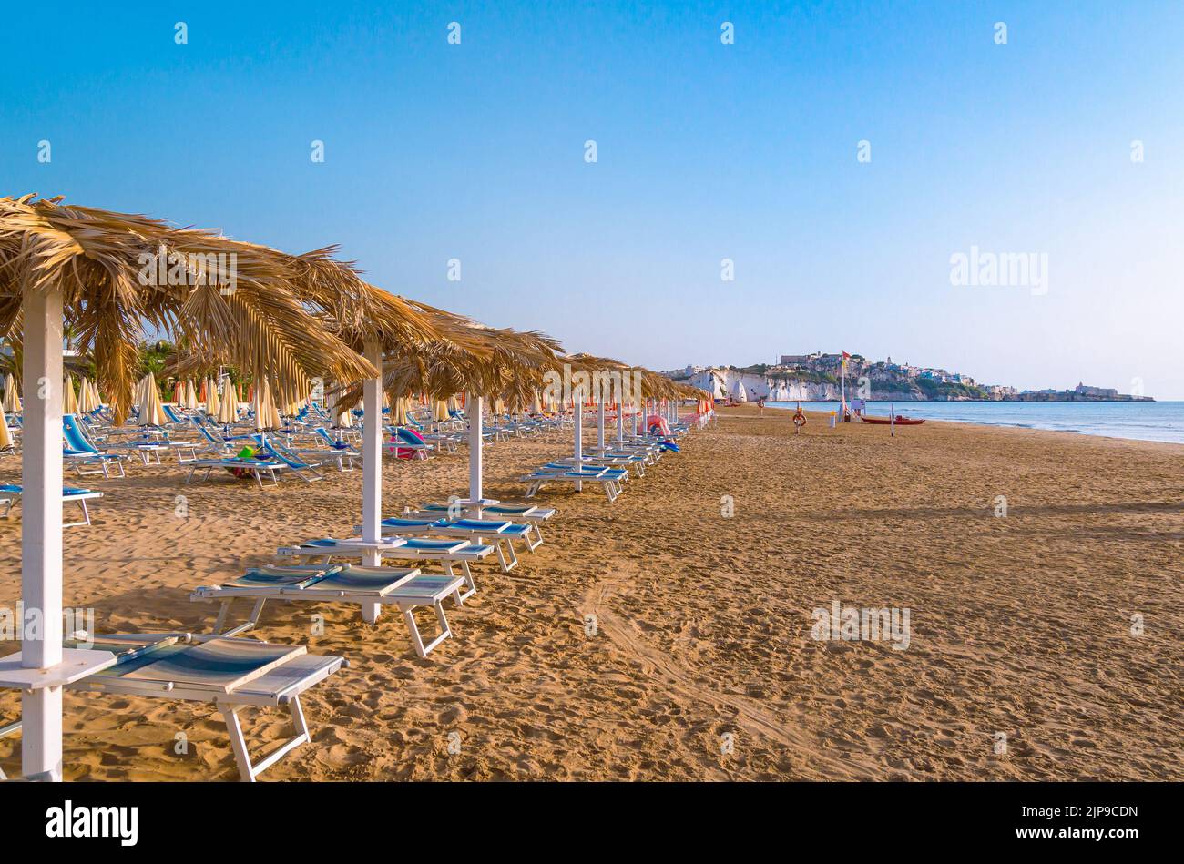 Vieste, Foggia, Italy 26 June 2021 Scialara, a sandy sunrise beach and in background on chalky rocks the oldtown of Vieste and the monolite Pizzomunno Stock Photo