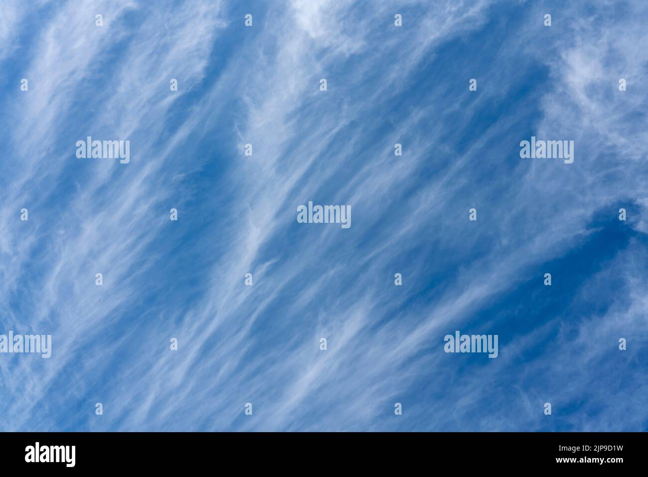 Dramatic cirrus white clouds on a blue sky for use as a cloudscape texture background, stock photo image Stock Photo