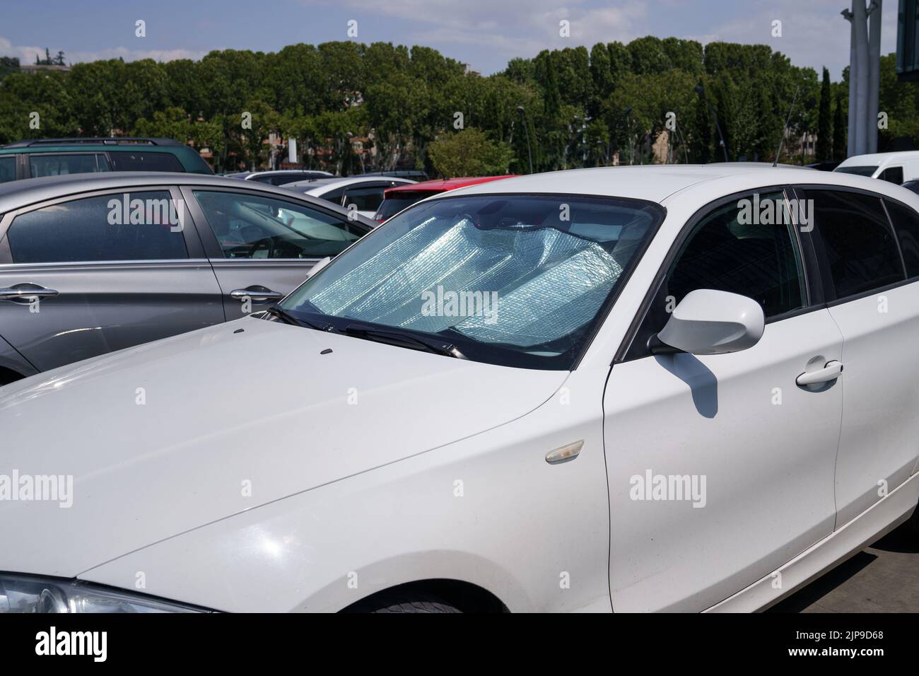 Protective reflective surface under windshield of car on hot day