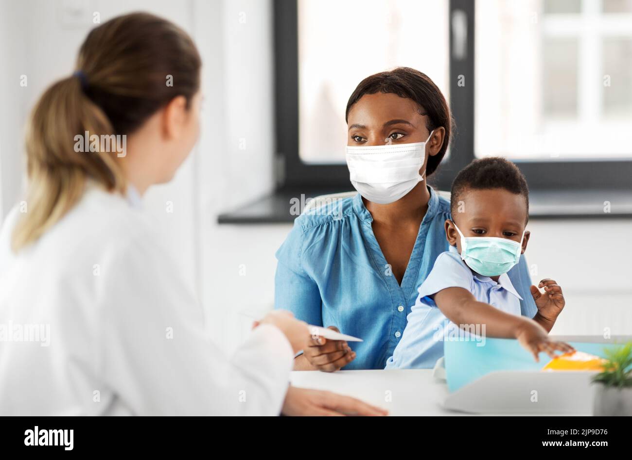 mother with baby son in masks and doctor at clinic Stock Photo - Alamy
