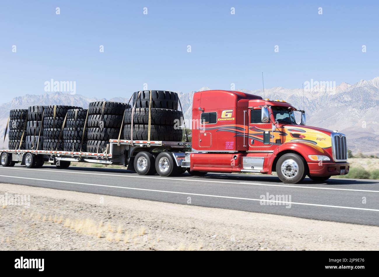 18-wheeler or semi truck shown hauling very large tires along Highway 395 near Lone Pine, Inyo County, California, USA. Stock Photo