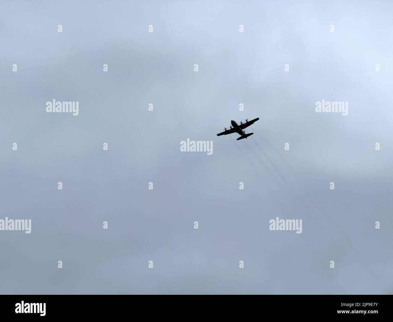 A cropduster plane flying under a gloomy sky Stock Photo