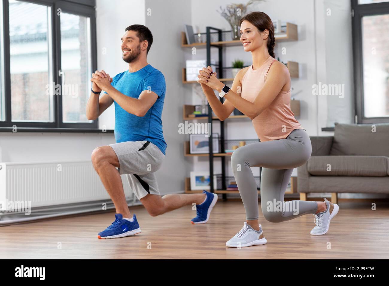 happy couple exercising and doing squats at home Stock Photo - Alamy