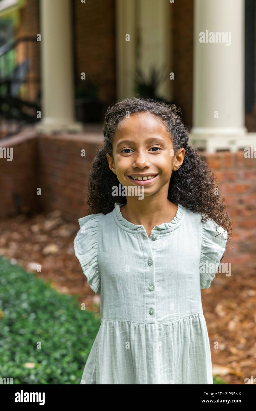Cute elementary aged girl standing outside her home Stock Photo - Alamy