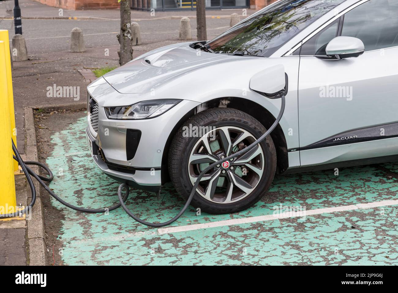 A Jaguar electric car charging on a city street, Glasgow, Scotland, UK, Europe Stock Photo