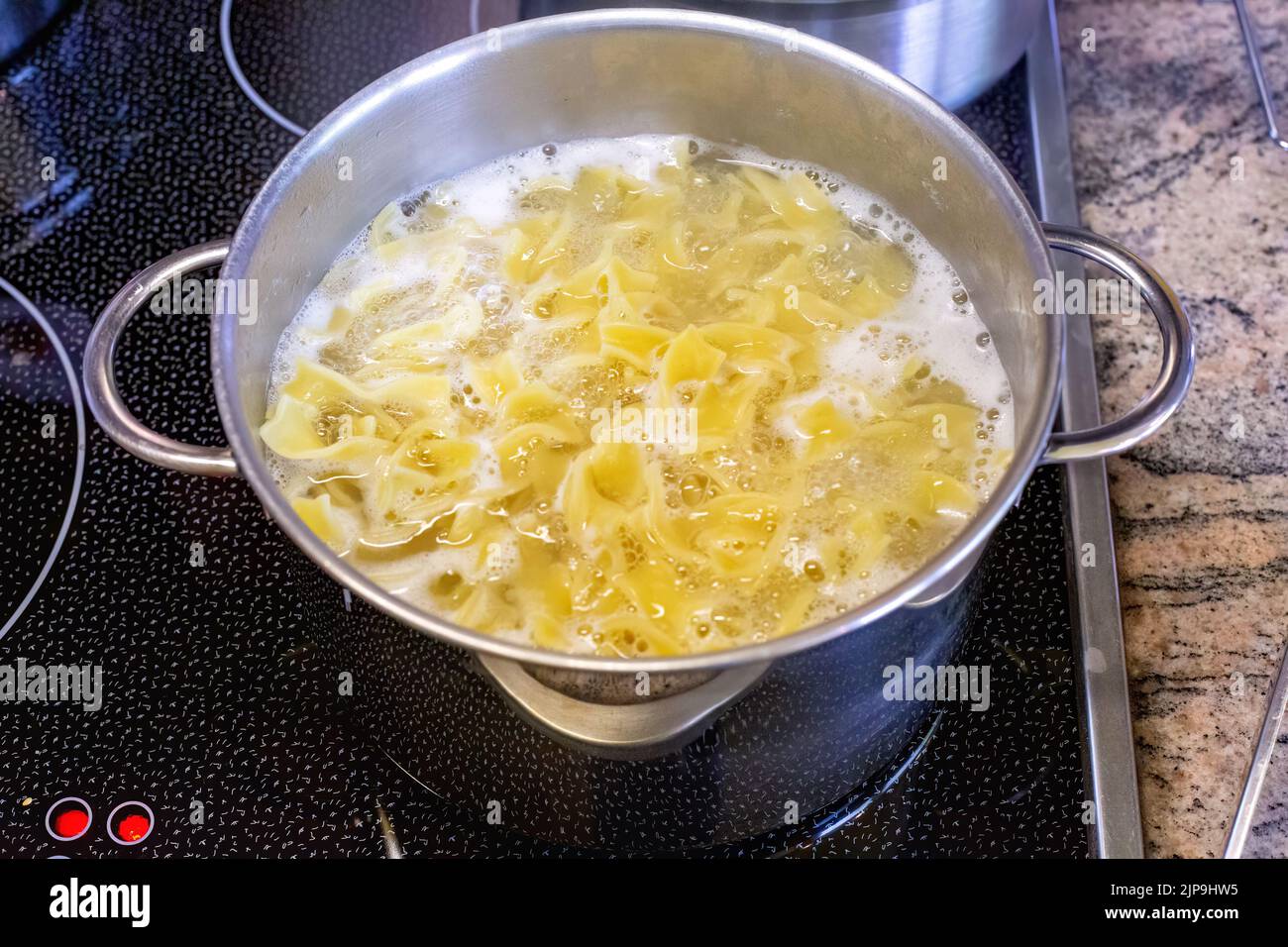close-up of stove with pot and pasta Stock Photo