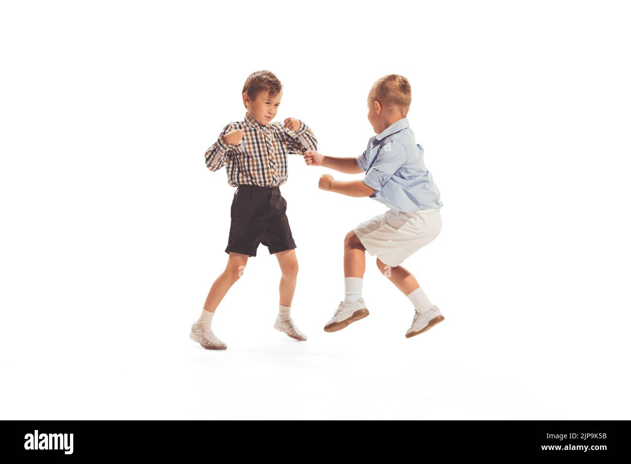 Portrait of two little boys, children playing together, having fun isolated over white studio background Stock Photo