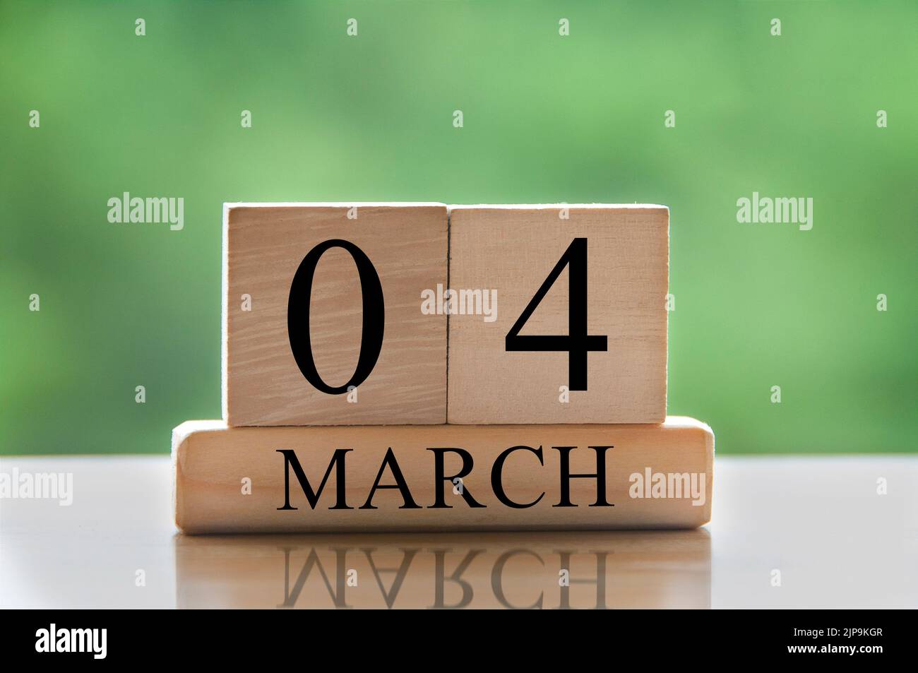 March 4 calendar date text on wooden blocks with blurred park background. Copy space and calendar concept. Stock Photo