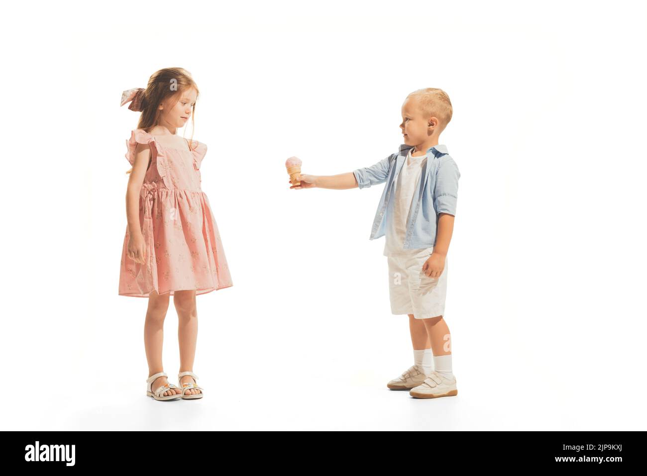 Portrait of children, little boy giving ice cream to beautiful girl