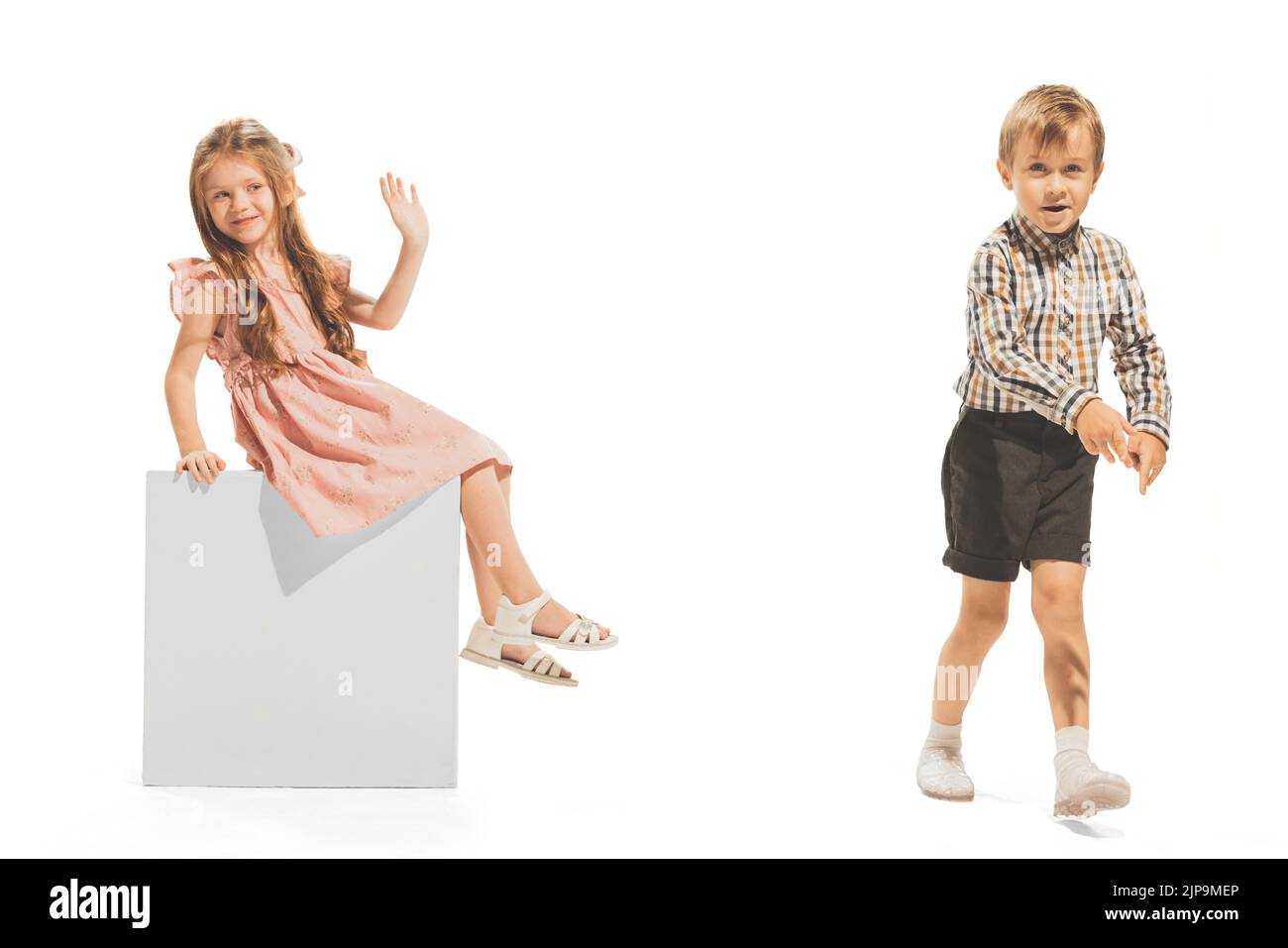Portrait of little boy and girl, children playing together isolated over white studio background. Having fun together Stock Photo