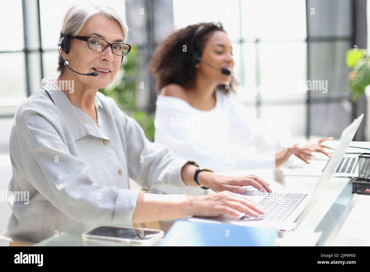 operator woman agent with headsets working in a call centre. Stock Photo