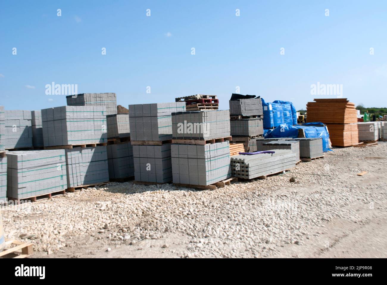 Stacked pallets of grey breeze cinder blocks blocks on a building site. Stock Photo