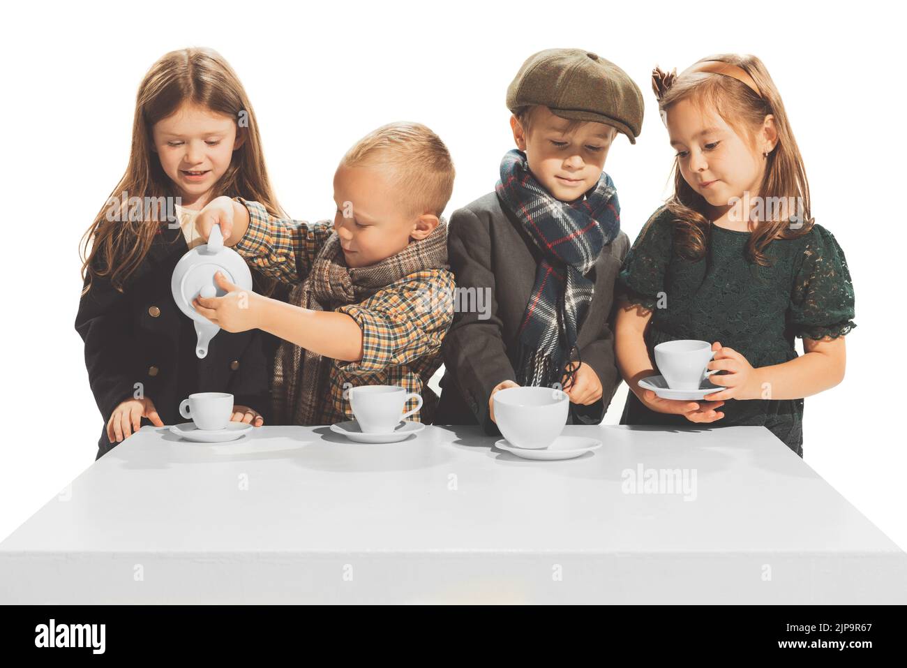 Portrait of beautiful children, boys and girls in stylish autumn clothes isolated over white studio background. Tea party. Stock Photo
