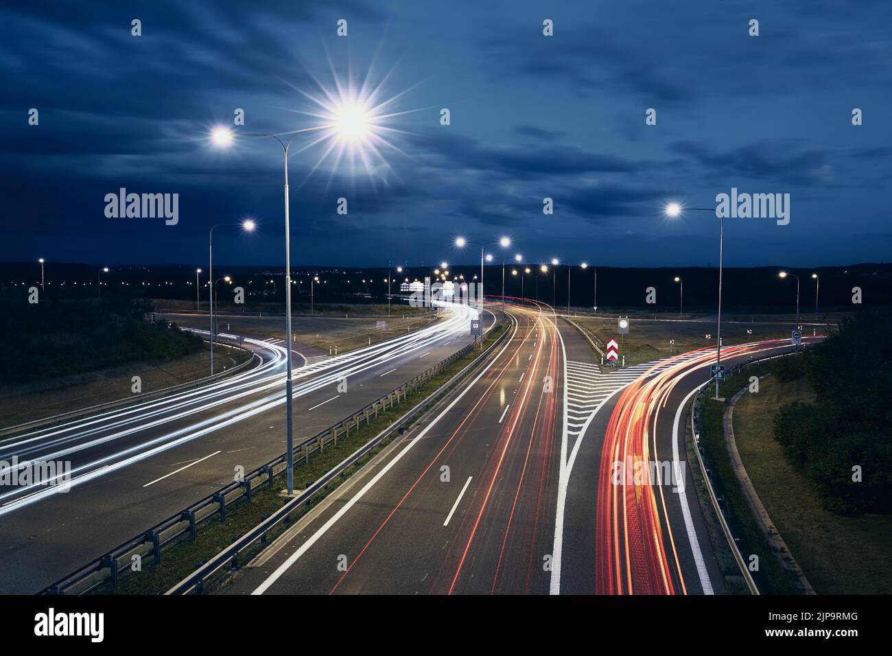 Light trails of cars. Traffic on illuminated highway at night. Stock Photo