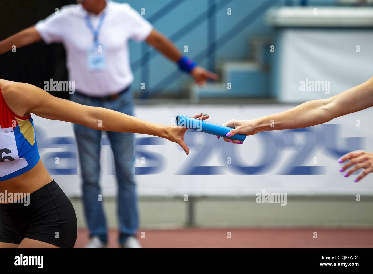 women relay race competition on background banner Paris 2024 Stock