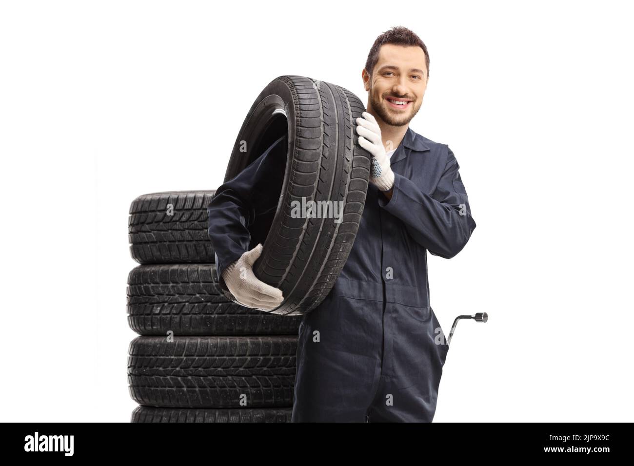 Car mechanic with a tire on his shoulder isolated on white background Stock Photo