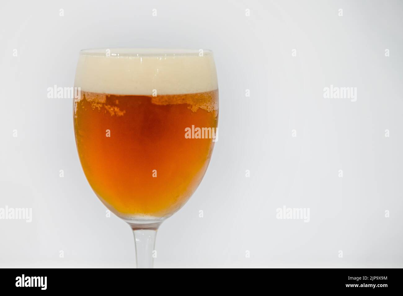 Ice cold beer glass on red background. Stock Photo