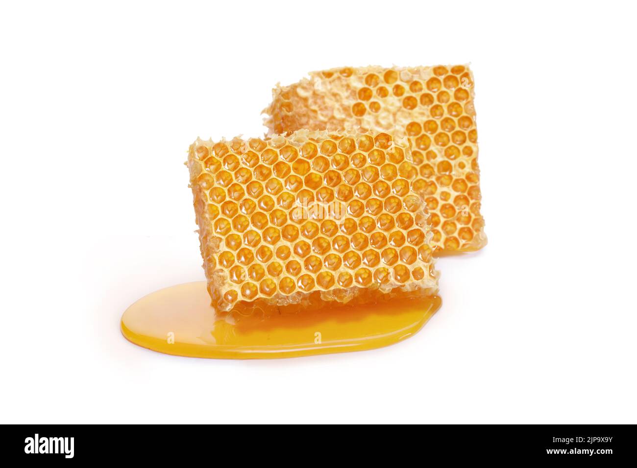 Pieces of a honeycomb with honey leaking around isolated on white background Stock Photo